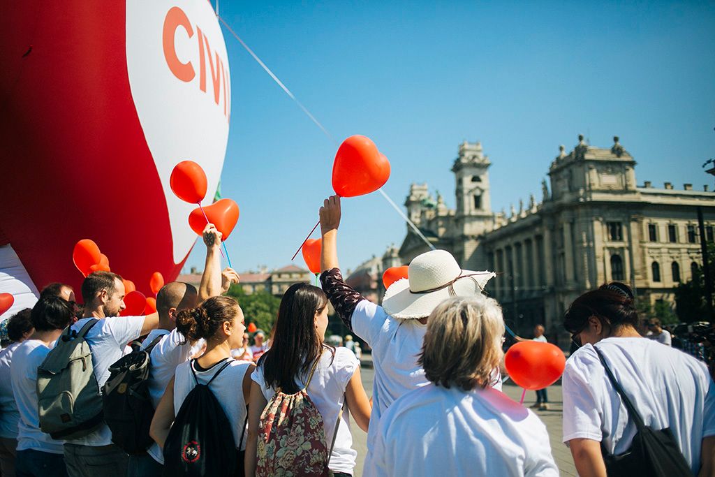 Szolidaritási akció a Parlamentnél a "Stop Soros" törvénycsomag ellen   Résztvevők egy szív alakú piros léggömb előtt az Amnesty International (AI) "Stop Soros" törvénycsomag ellen tartott szolidaritási akcióján a Parlament előtti Kossuth téren 2018. június 4-én. A képviselők június 5-én folytatják le az egyes törvényeknek a jogellenes bevándorlás elleni intézkedésekkel kapcsolatos módosításáról szóló törvényjavaslat, azaz a "Stop Soros" vitáját. Fotó: Horváth Péter Gyula