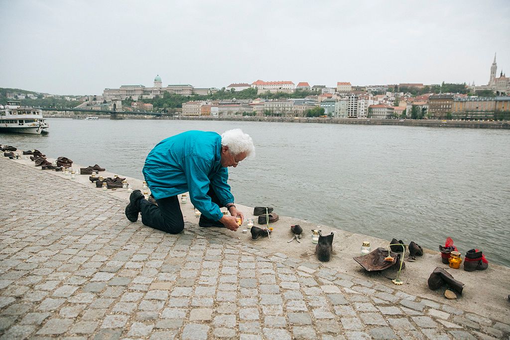 Mécsest gyújt a holokauszt magyarországi áldozatainak emléknapja alkalmából tartott megemlékezés egyik résztvevője a fővárosi Cipők a Duna-parton emlékműnél 2018. április 16-án. Fotó: Horváth Péter Gyula