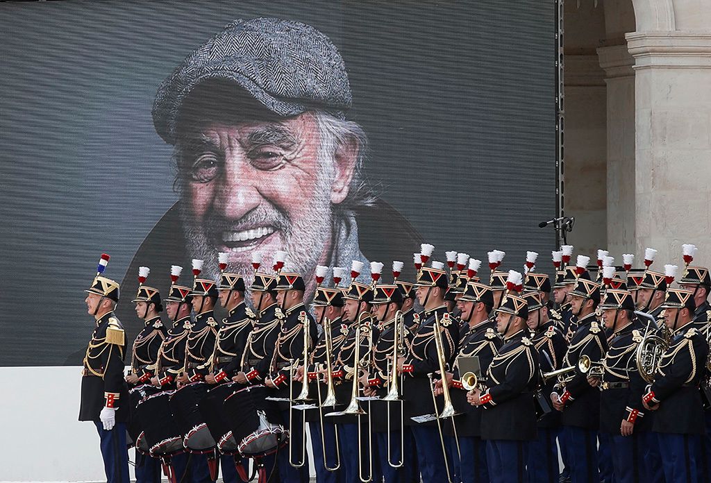 Paul Belmondo francia színészt ábrázoló kép előtt áll a színész állami gyászszertartásán a párizsi Invalidusok díszudvarán MTI/EPA pool/Ian Langsdon