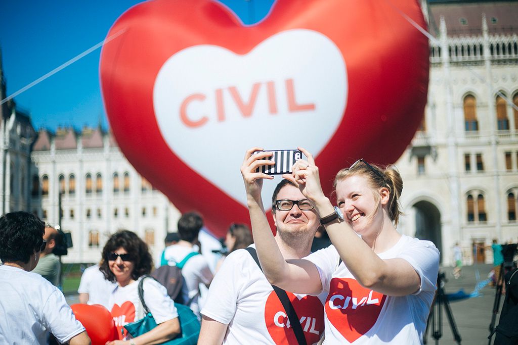 Szolidaritási akció a Parlamentnél a "Stop Soros" törvénycsomag ellen   Résztvevők egy szív alakú piros léggömb előtt az Amnesty International (AI) "Stop Soros" törvénycsomag ellen tartott szolidaritási akcióján a Parlament előtti Kossuth téren 2018. június 4-én. A képviselők június 5-én folytatják le az egyes törvényeknek a jogellenes bevándorlás elleni intézkedésekkel kapcsolatos módosításáról szóló törvényjavaslat, azaz a "Stop Soros" vitáját. Fotó: Horváth Péter Gyula