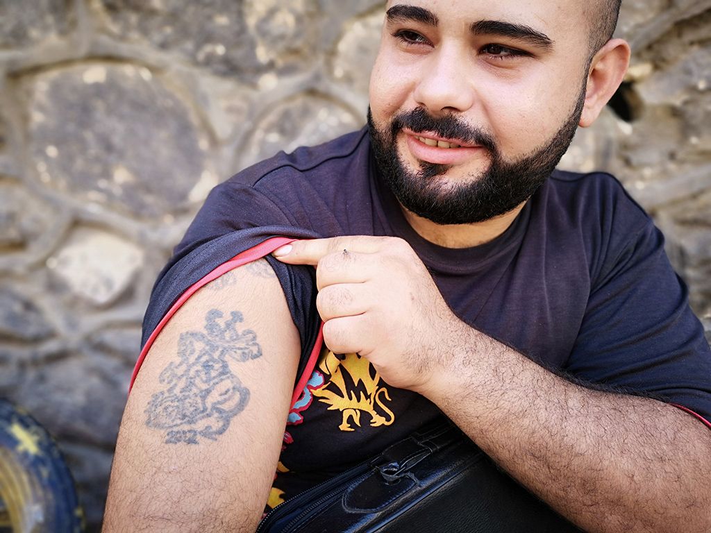 Keresztény férfi mutatja büszkén tetoválását Szemétváros egyik kávézójában Fotó: Mark Younanis.
