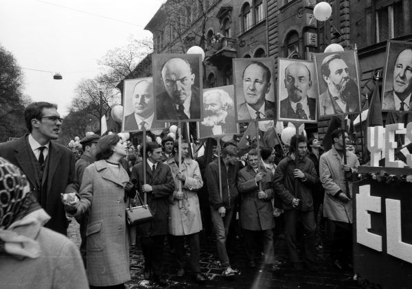 Május elsejei felvonulás a Kádár-korszakban. A résztvevők Marx, Engels, Lenin és Kádár portréival vonulnak a Városligethez, hogy integessenek a dísztribünön helyet foglaló kommunista pártvezetőknek, köztük Kádár János pártfőtitkárnak. Fotó: Fortepan