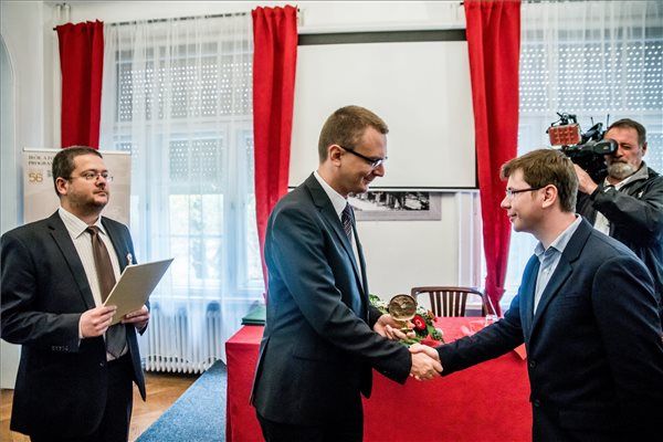 Rétvári Bence, az Emberi Erőforrások Minisztériuma (EMMI) parlamenti államtitkára (k) átadja a Gérecz Attila-díjat Korpa Tamás költőnek az 1956-os forradalom és szabadságharc 60. évfordulóján rendezett megemlékezésen a Magyar Írószövetség fővárosi székházában 2016. október 23-án. MTI Fotó: Balogh Zoltán
