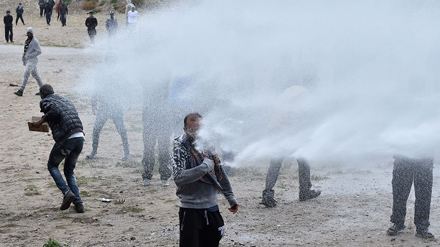 French police use water canons against participants during a march in support of migrants and refugees in the so-called 'Jungle' camp in the French northern port city of Calais on October 1, 2016. Between 7,000 and 10,000 migrants are currently living in the