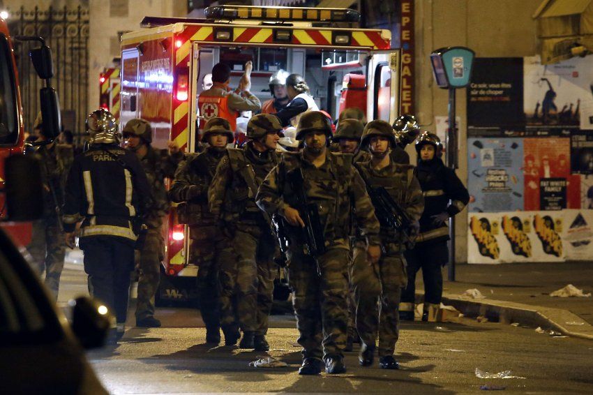 Soldiers walk in front of an ambulance as rescue workers evacuate victims near La Belle Equipe, rue de Charonne, at the site of an attack on Paris on November 14, 2015 after a series of gun attacks occurred across Paris as well as explosions outside the national stadium where France was hosting Germany. More than 100 people were killed in a mass hostage-taking at a Paris concert hall and many more were feared dead in a series of bombings and shootings, as France declared a national state of emergency. AFP PHOTO / PIERRE CONSTANT