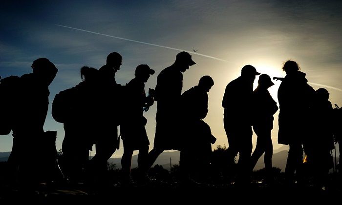 epa04917414 Refugees walk after crossing the border between Macedonia and Greece, near the town of Gevgelija, The Former Yugoslav Republic of Macedonia, 06 September 2015. The Gevgelija-Presevo journey is just a part of the journey that the refugees, the vast majority of them from Syria, are forced to make along the so-called Balkan corridor, which takes them from Turkey, across Greece, Macedonia and Serbia to Hungary, the gateway to the European Union. EPA/NAKE BATEV