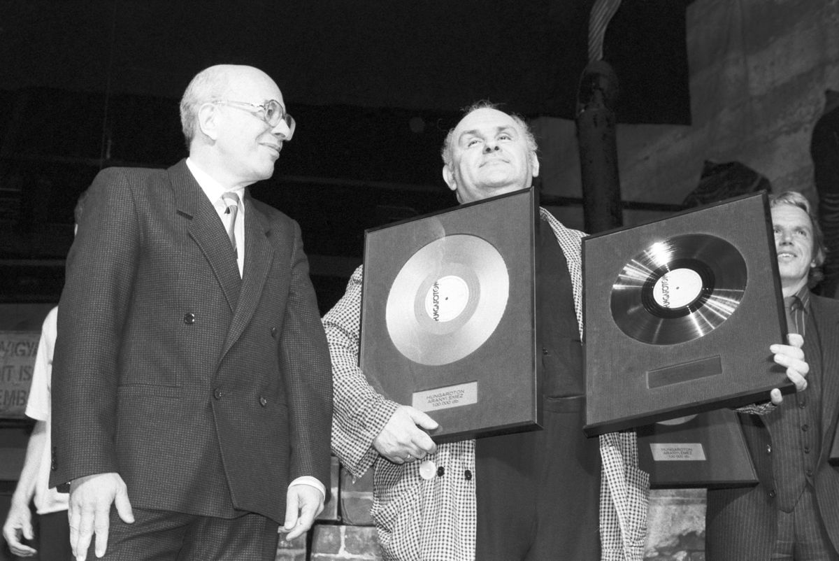 Hofi Géza elõadómûvész (k) a 250 ezer példányban eladott Hofélia címû elõadásból készült korongért járó arany- és platinalemezét tartja a kezében, melyet Bors Jenõtõl, a Hanglemezgyár vezérigazgatójától (b) vett át / Fotó: MTI