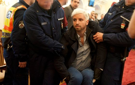 A kormányellenes tüntetések vezéralakját, Gulyás Mártont éppen a Fővárosi Közgyűlésről viszik el a rendőrök. Fotó: mandiner.blog.hu