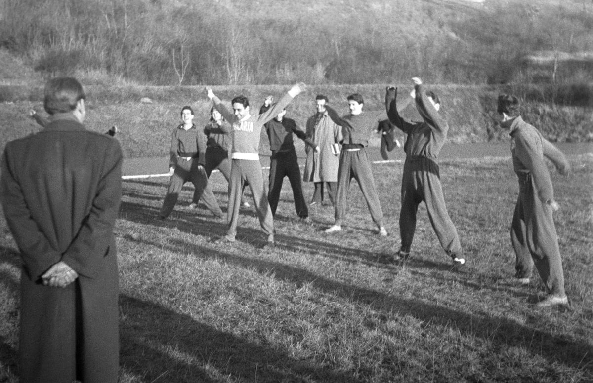 Az olimpiai atlétikai keret tagjai szabadtéri gimnasztikát végeznek Iglói Mihály edzõ (b) vezetése mellett a Vasas Pasaréti úti pályáján. 1952 / Fotó: MTI