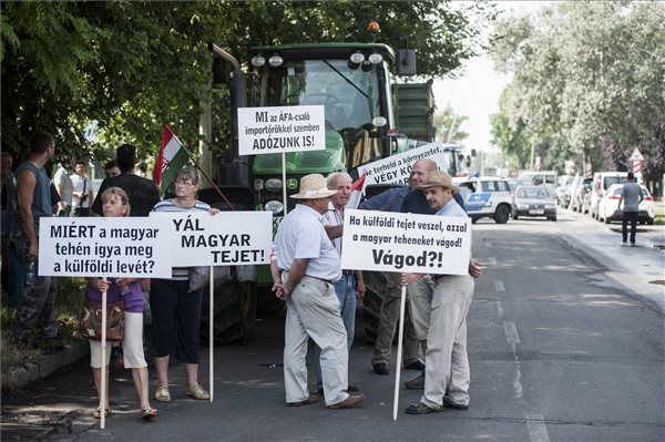 Résztvevők transzparensekkel a kezükben a Mecsek Füszért logisztikai bázisa előtt Pécsett a tejtermelők demonstrációján 2014. július 8-án. MTI Fotó: Sóki Tamás