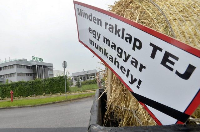 Nagytarcsa, 2014. július 8. Transzparens egy teherautón egy szalmabála mellett a tejtermelõk demonstrációján a Foltin Globe Kft. nagytarcsai logisztikai központjánál 2014. július 8-án. A termelõk a tiltakozással a fogyasztók figyelmét szeretnék felhívni arra, hogy részesítsék elõnyben a magyar tejtermékeket az importtal szemben, valamint figyelmeztetni akarnak egyes, szerintük aránytalanul nagy mennyiségben import tejtermékeket forgalmazó kereskedõket arra, hogy preferálják a magyar tejtermékeket. MTI Fotó: Máthé Zoltán