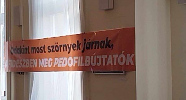 A korrupciós botránynál már csak a terelési kísérlet kellemetlenebb. Előkészített plakáttal várták a DK-sok a testületi ülést.