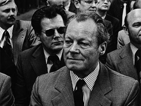 Elől a kancellár, mögötte a Stasi embere - fekete napszemüvegben, ahogy kell /Fotó: Alchetron.com