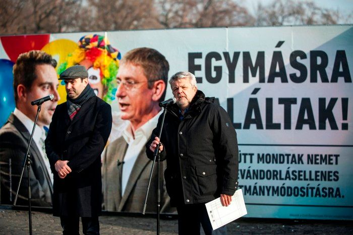 Budapest, 2016. december 7. Ifj. Lomnici Zoltán, a Civil Összefogás Fórum (CÖF) szóvivõje, a CÖKA közjogi kabinetjének vezetõje (b) és Csizmadia László, a CÖF alapítója a szervezet újabb plakátkampányának sajtótájékoztatóján a budapesti Ötvenhatosok terén 2016. december 7-én. A háttérben lévõ plakáton Vona Gábor Jobbik-elnököt és Gyurcsány Ferenc DK-elnököt öleli át a korábbi plakátkampányból ismert bohóc, a felirat pedig azt hirdeti: Egymásra találtak! Együtt mondtak nemet a bevándorlásellenes alkotmánymódosításra. MTI Fotó: Marjai János