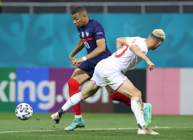 Mbappé húzza el a labdát Xhaka mellett. Fotó: MTI/EPA/REUTERS/Marko Djurica