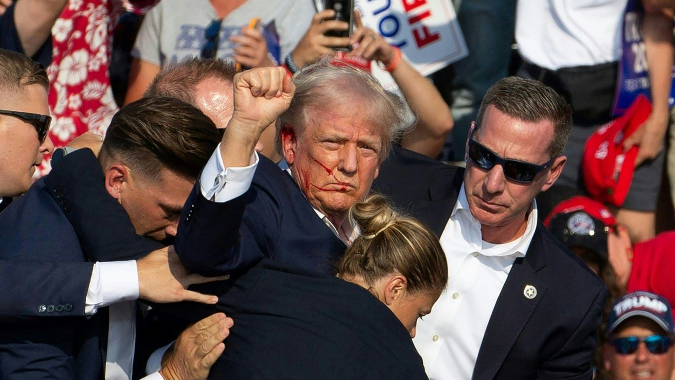 Donald Trump amerikai elnököt véres arccal vezetik le a színpadról a Secret Service emberei a Pennsylvania állambeli Butlerben, 2024. július 13-án ( AFP / Rebecca DROKE)